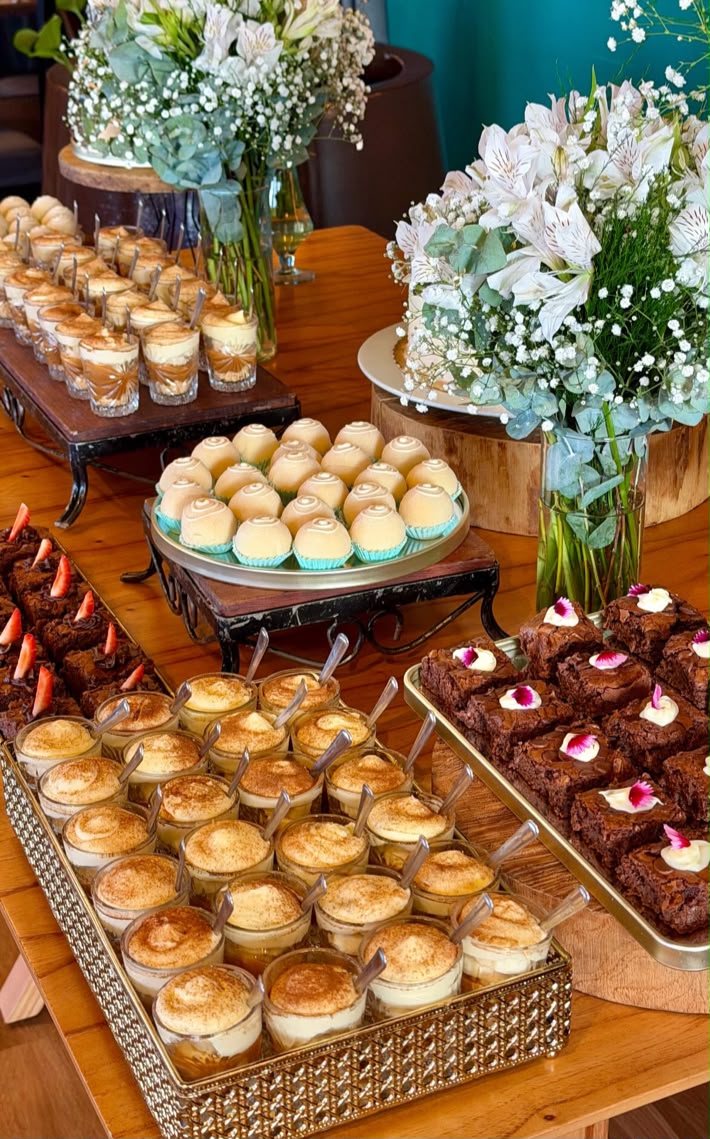Mesa de doces com brownies, copinhos de sobremesa e arranjo floral