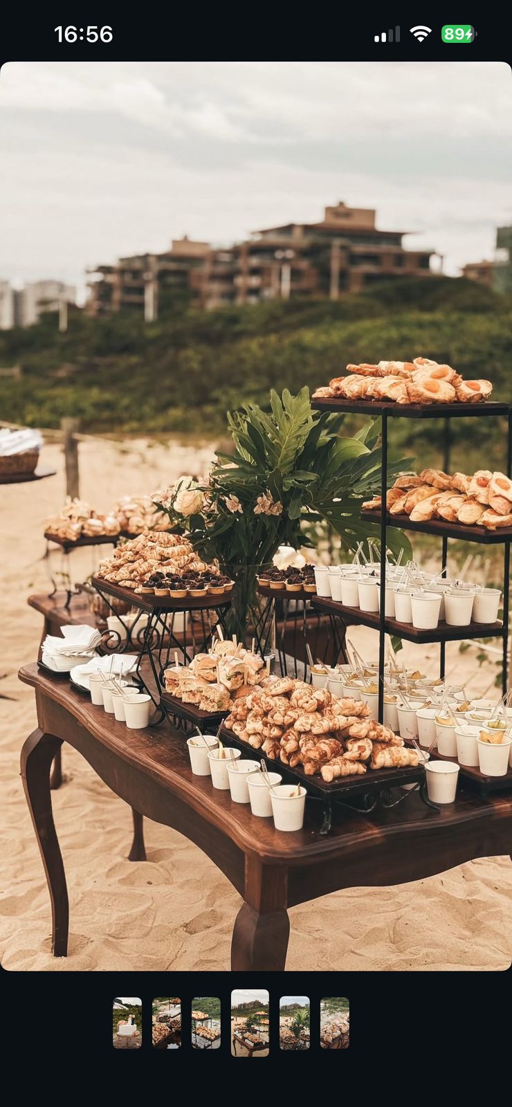 Buffet ao ar livre sobre a areia com folhados, doces e bebidas