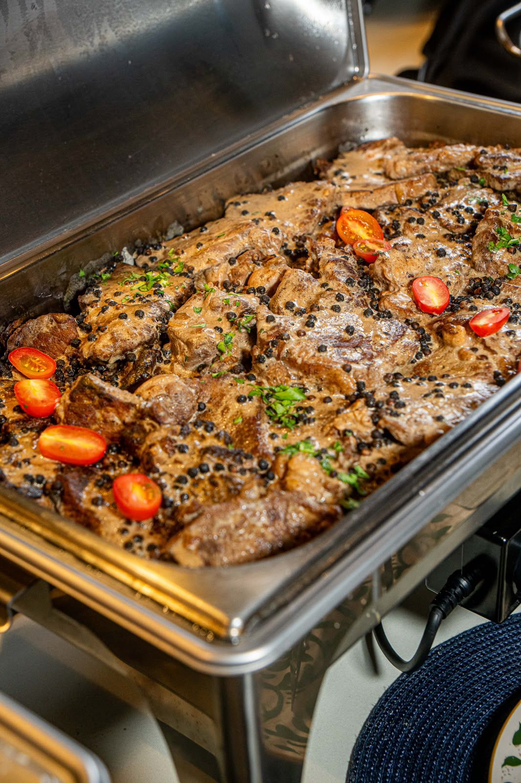 Réchaud com carnes ao molho de mostarda e pimenta verde no serviço do evento